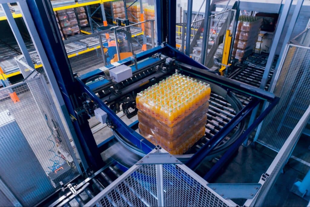 Automatic strapping and stretch wrapping machinery at the end of a conveyor line