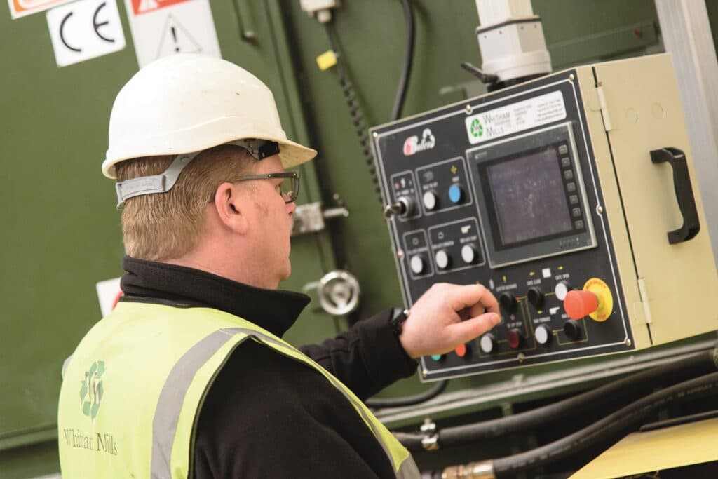Engineer operating bespoke handling machinery on a factory floor