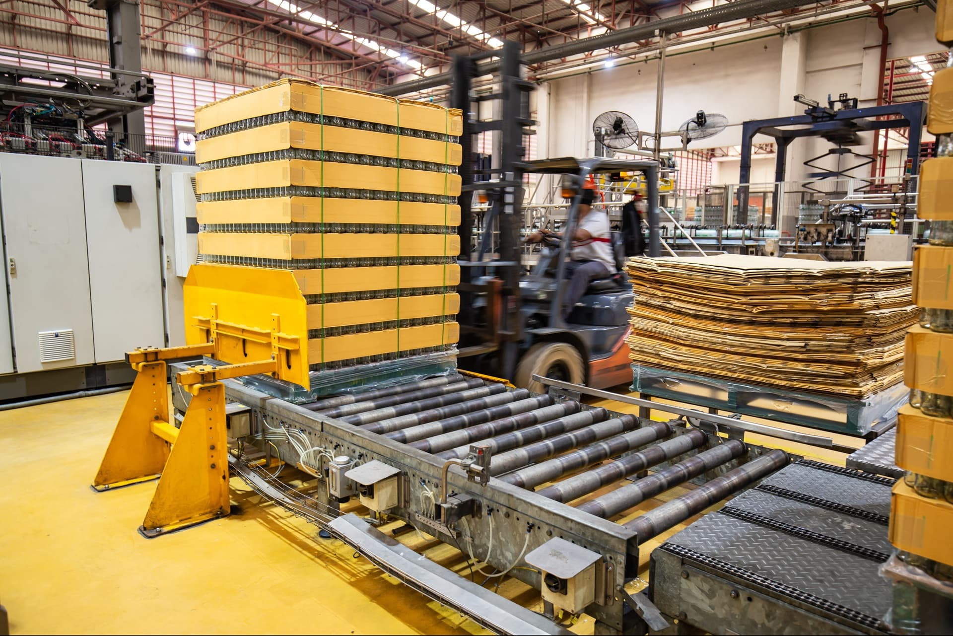 Pallet handling conveyor line moving loaded pallets through a factory